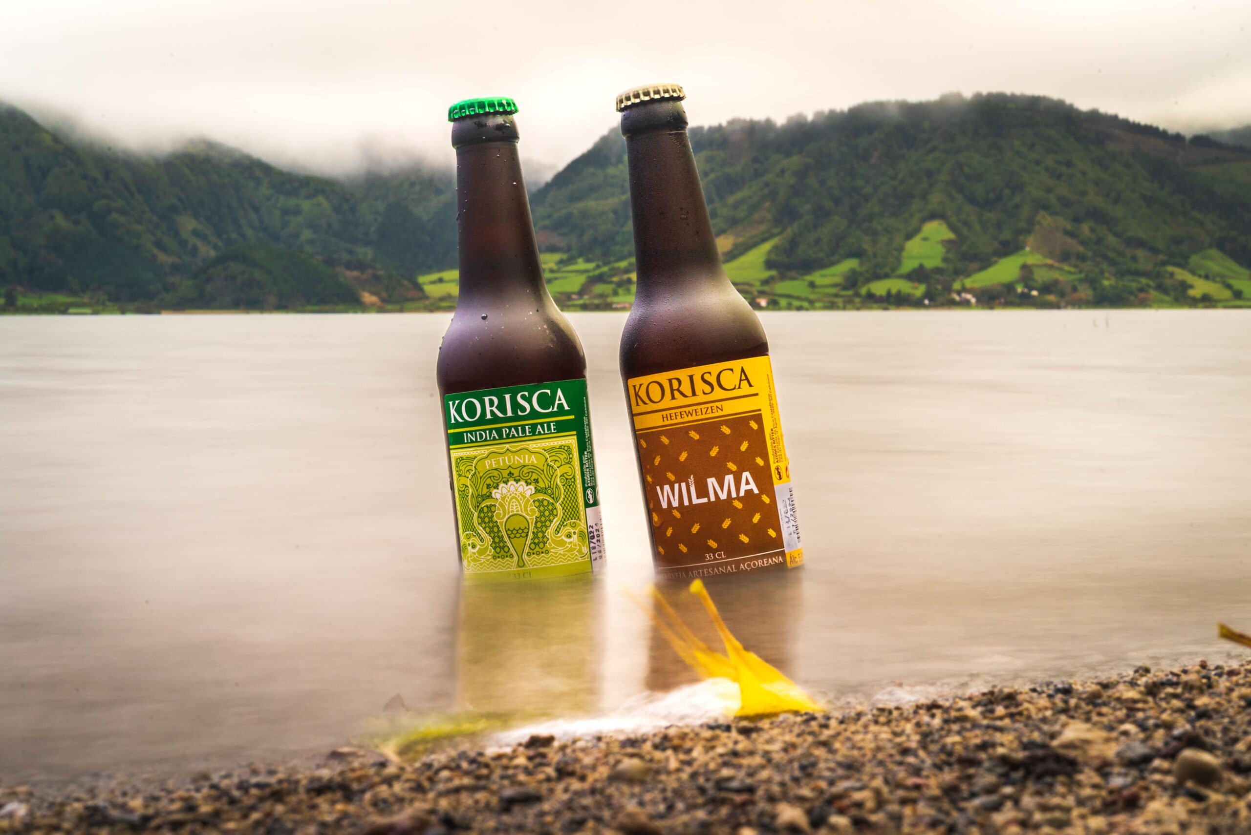 Cerveja artesanal Korisca, Petúnia (IPA) e Wilma (Hefeweizen), dentro da Lagoa das Sete Cidades, com o vale verde de fundo, Sete Cidades, Ponta Delgada, São Miguel, Açores.