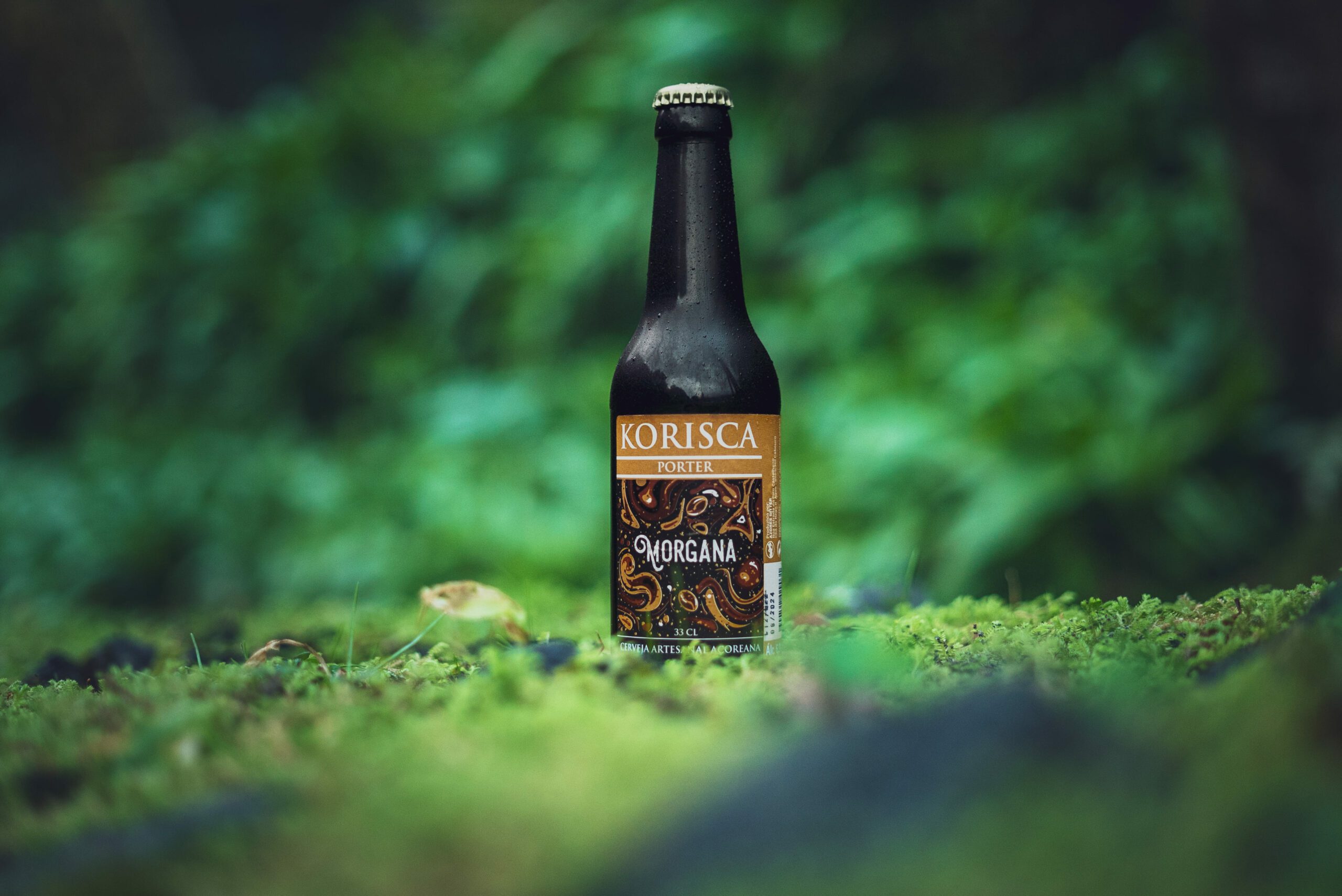 Korisca Morgana Azorean craft beer (Porter) on the green floor, surrounded by green vegetation, in Sete Cidades, Ponta Delgada, São Miguel, Azores.